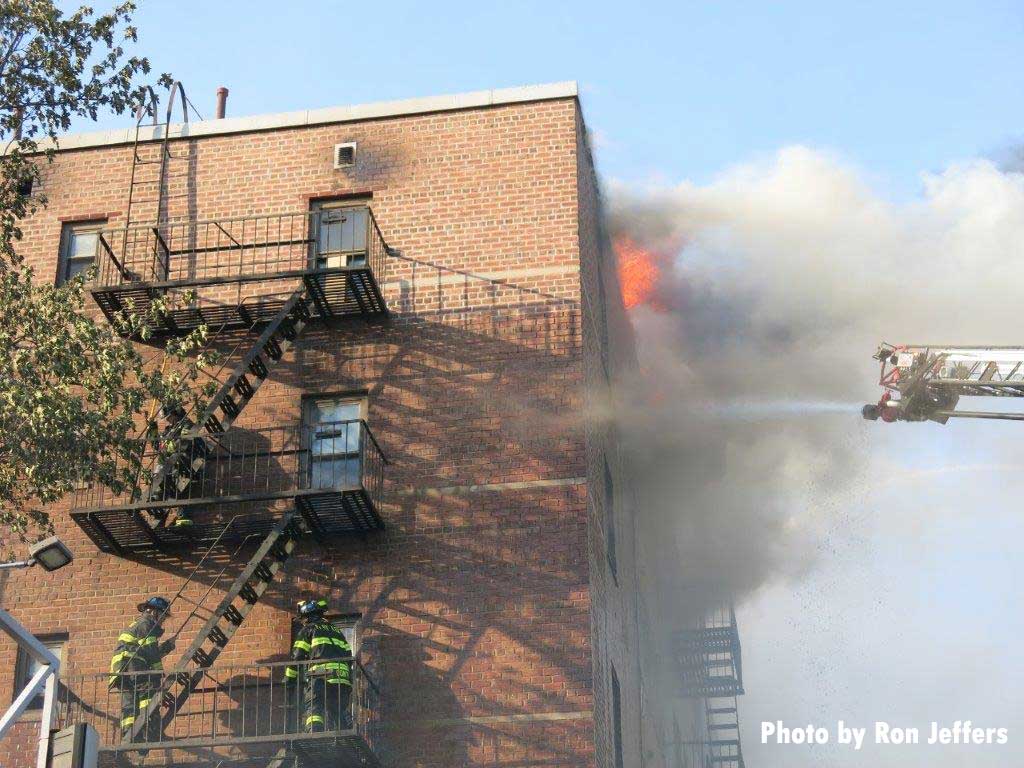 消防队员从空中将水注入公寓火灾的火焰中逃生