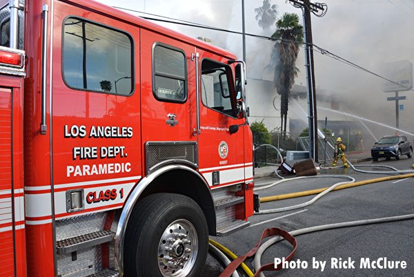 消防设备和消防员在洛杉矶范奈斯区的一场大火现场。