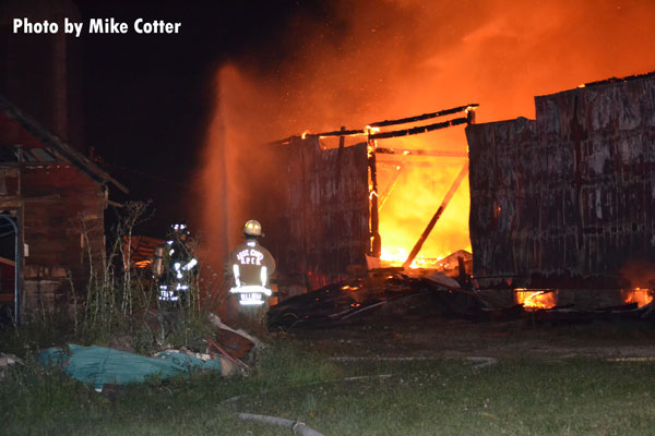 在威斯康辛州麦地那市，消防队员正在用水管灭火。