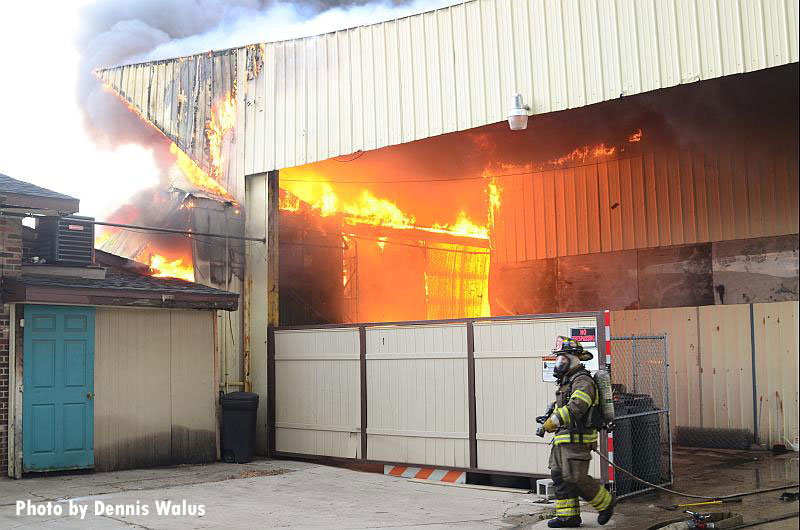 一场大火在一幢商业建筑中肆虐，消防队员正在接近。