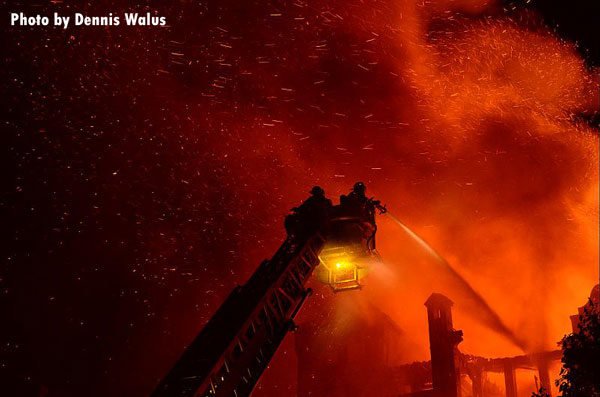 底特律的消防队员在一间公寓的冷杉处从空中操作一条溪流。