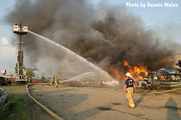 在密歇根州沃伦市的一个垃圾场，消防员在燃烧的车辆上训练空中气流。