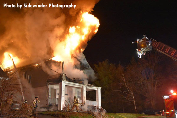 消防员operating at the scene of a two-alarm dwelling fire in Troy, New York.