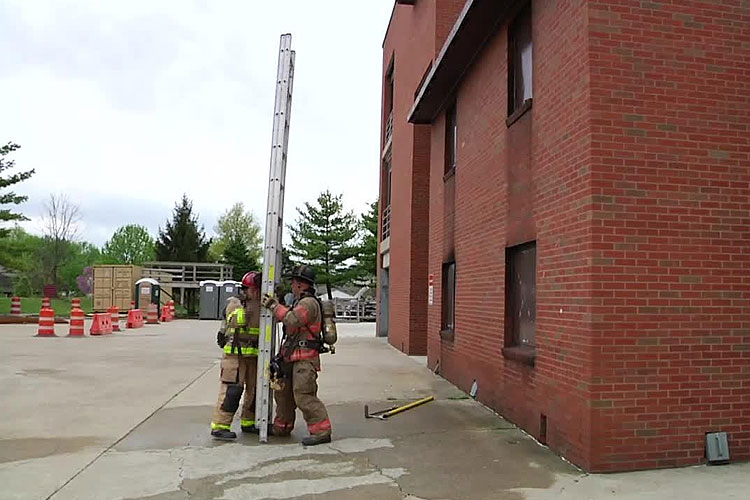 消防队员在建筑物外升起梯子
